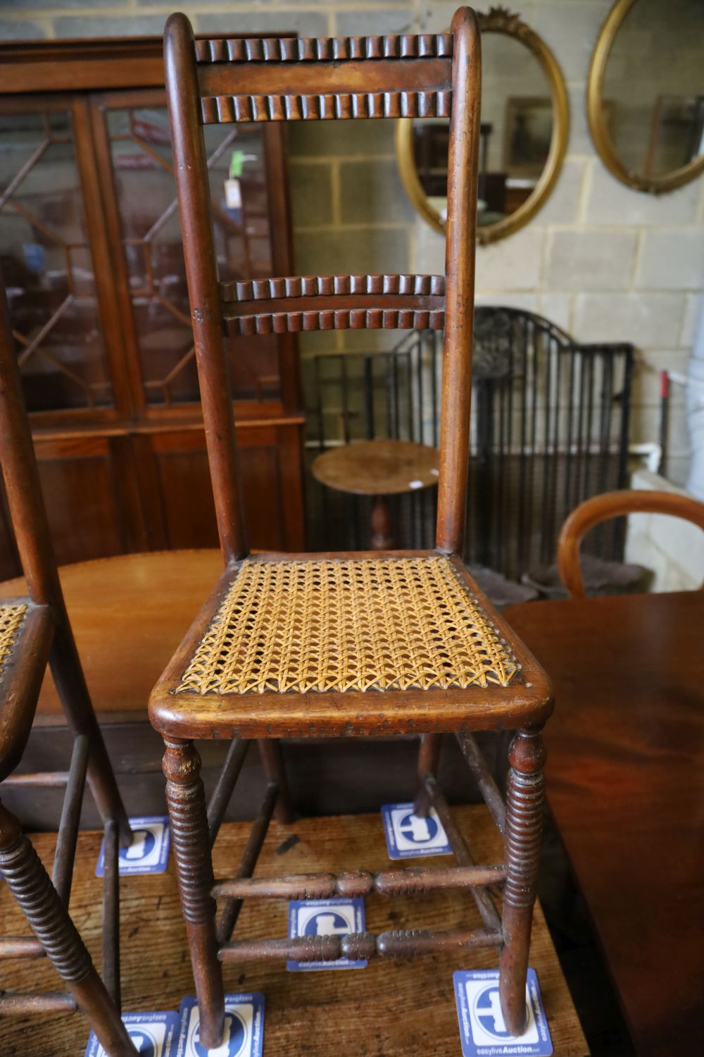 A pair of Regency provincial cane seat correction chairs (one cut down)